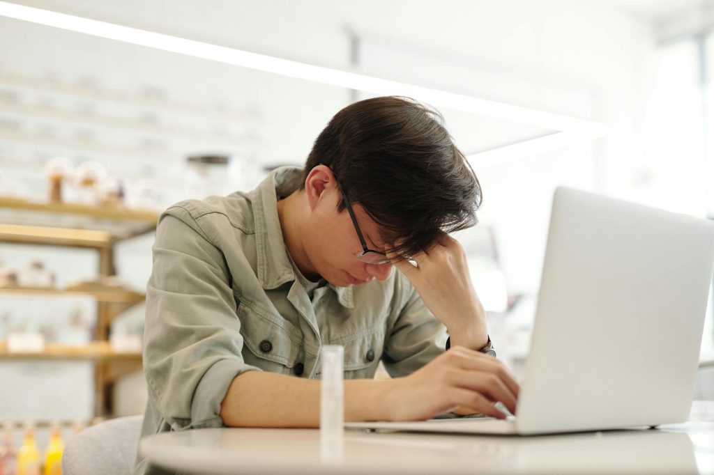 a man looking sick while working with his laptop